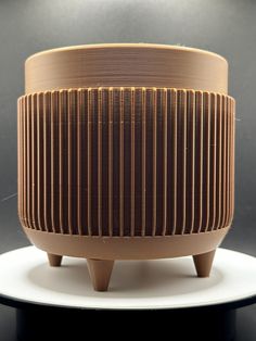 a brown and white object sitting on top of a black table next to a gray wall