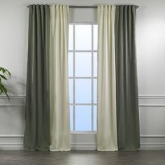 a living room filled with furniture and a large window covered in green drapes next to a potted plant