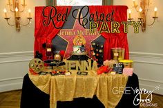 the table is set up for a movie themed birthday party with red curtains and decorations