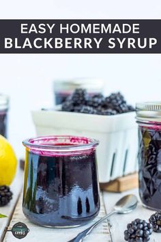 homemade blackberry syrup in jars with blueberries and lemons