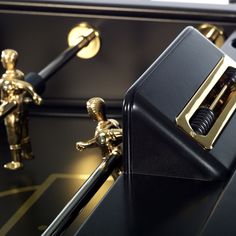 two golden figurines stand next to a black and gold locker with metal handles