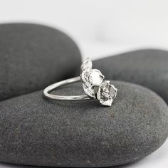 This adjustable ring has two different hand-carved flowers perched on top of a smooth silver band. There's a gap in the band between the flowers, giving them a light, floating appearance. There are little silver beads in their centers and at the tips of their petals. The flowers will drift apart on larger sizes and stack on top of each other in smaller sizes. Made from solid recycled sterling silver, please inquire about 14K.Flowers are 9 and 12mm along their diagonals. Adjustable Sterling Silver Promise Flower Ring, Adjustable White Gold Flower Ring For Promise, Silver Nature-inspired Open Flower Ring, Nature-inspired Silver Open Flower Ring, Adjustable Silver Flower Ring Nature-inspired, Delicate Adjustable Toe Flower Ring, Delicate Silver Flower Open Ring, Adjustable Open Flower Ring In White Gold, Nature-inspired Silver Flower Ring For Anniversary