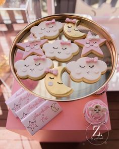 some cookies that are sitting in a tin on top of a pink table cloth and gold tray