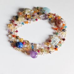 This colorful , beaded , handwrapped necklace is made with a great variety of  different gemstone :  Peridot, Apatite, Citrine, Rose Quarz,Rhodolite Garnet,Iolite, Acquamarine, iolite, apatite, red agate, green onyx,  Amethyst , Carnelian  Tourmaline and few ruby This  versatile Necklace will be perfect   as an every  day jewel. Great as layering necklace, beautiful to wear with other necklaces or as a bracelet, wrapped around your wrist The necklace measures 103 cm    40.55  inches  Gemstones r Paper Gift Box, Rhodolite Garnet, Red Agate, Green Onyx, Layered Necklaces, Long Necklace, Citrine, Tourmaline, Garnet