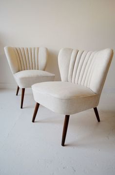 two white chairs sitting next to each other