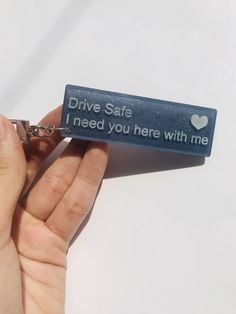 someone is holding a key chain that says drive safe, need you here with me