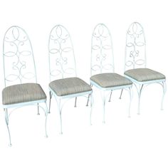 four white metal chairs sitting next to each other