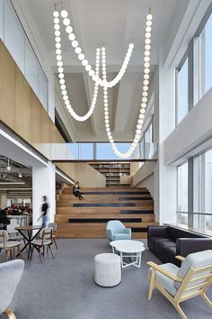 a large open space with lots of furniture and lights hanging from it's ceiling