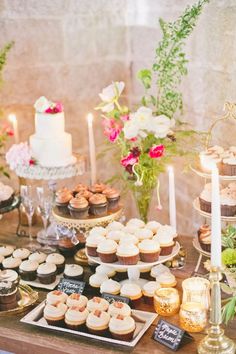 a table topped with lots of cupcakes and cakes