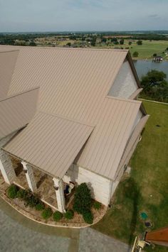 an aerial view of a large white building with a lake in the backround