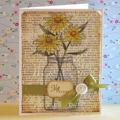 a card with yellow daisies in a mason jar on it's side and a green ribbon around the edge