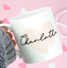 a person holding a coffee mug with the word charlotte written on it