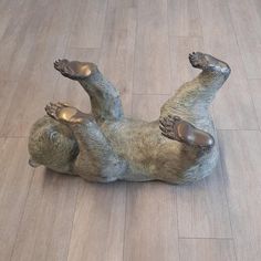 a statue of a bear laying on it's back with its legs spread out