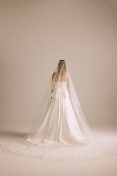 the back of a bride's wedding dress, with her veil draped over her shoulder