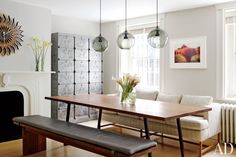 a dining room table and bench in front of a fireplace