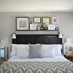 a bed with white sheets and pillows in a bedroom next to pictures on the wall