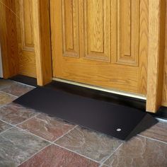 a door mat is on the floor in front of a wooden door with a black handle