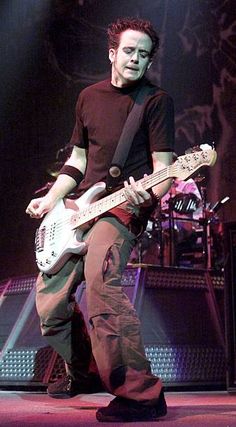 a young man playing an electric guitar on stage