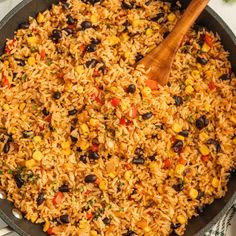 mexican rice and beans in a skillet with a wooden spoon