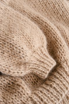 a close up of a knitted blanket on a bed