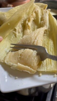 a white plate topped with pineapple slices and a fork next to an uncooked banana