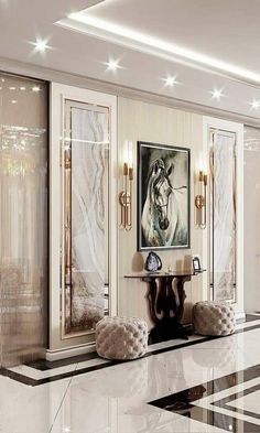 an elegant living room with marble floors and white walls, along with art work on the wall