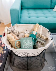 a basket filled with personal care items sitting on top of a glass table next to a blue couch