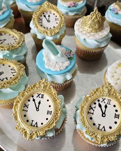 cupcakes with blue frosting and gold trim around the edges are decorated with clocks