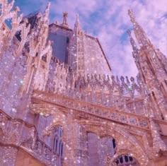 an ornate building with lots of lights on it's front and side windows in the sky