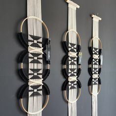 three wall hangings with black and white designs on the sides, one is made out of rope