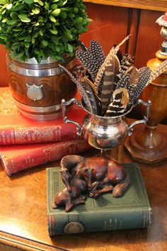 an elephant figurine sitting on top of a book next to a potted plant