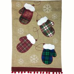 a christmas stocking with mittens and snowflakes hanging on a burlock