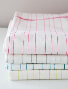 three folded sheets are stacked on top of each other in different colors and patterns,