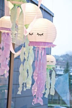 paper lanterns with eyes and hair hanging from the ceiling