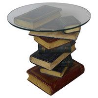 a stack of books sitting on top of each other under a glass topped coffee table