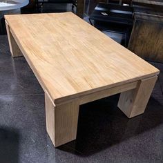 a wooden table sitting on top of a tiled floor