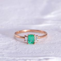 "Rectangular Cut Emerald Three Stone Ring with Baguette Cut Diamonds / Baguette Cut Emerald Ring / 14K Rose Gemstone Ring Our designs are based on colors of life and each color identifies a motion, a feeling, an emotion and style in each person's life. Through time, Emerald Stone has been known as a symbol of truth and love with its unique Green Color. In ancient Greece and Rome, Emerald was said to be the Gemstone of the Goddess Venus, purveyor of love and hope. On the other side of the world, Wedding Emerald Ring With Square Cut, Classic Wedding Emerald Cut Emerald Ring, Classic Rectangular Emerald Wedding Ring, Fine Jewelry Rectangular Emerald Ring, Three Stone Rectangular Diamond Jewelry, Rectangular Three Stone Diamond Jewelry, Wedding Jewelry With Baguette Diamonds In Rectangular Setting, Elegant Emerald Ring With Rectangular Stone For Wedding, White Gold Three Stone Rectangular Jewelry