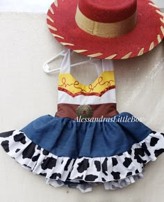 a cowgirl outfit with a cowboy hat on the top, and a dress made out of fabric