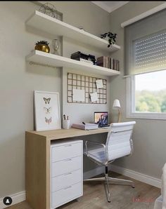 a white desk sitting under a window next to a lamp and book shelf on top of a wooden floor