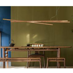 a wooden table with two chairs and a light hanging from it's center beam