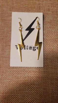 Gold Tone Lightning Bolt  Material is Brass These earrings sparkle beautifully! MEASUREMENTS: 2 INCHES LONG Gold Edgy Dangle Jewelry, Edgy Gold Dangle Jewelry, Edgy Gold Earrings For Party, Edgy Gold Jewelry For Party, Edgy Gold Metal Earrings, Sparkle Earrings, Lightning Bolt, Rock And Roll, Jewelry Earrings Dangle