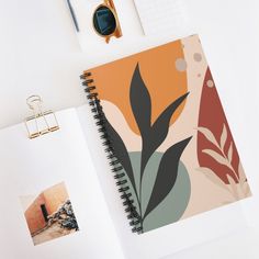 an open spiral notebook on top of a desk next to a pair of eyeglasses