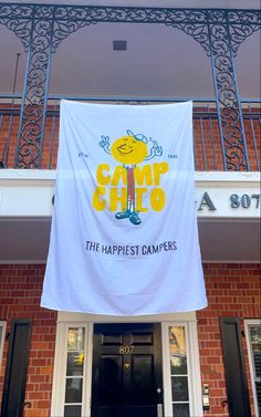 a banner hanging from the side of a building that says camp chicq, the happpiest campers