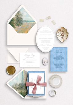 the wedding stationery is laid out on top of each other, including two envelopes and