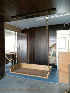 a wooden swing in the middle of a room