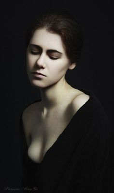 a woman with her eyes closed and dark hair in an artistic fashion photo, wearing black