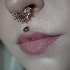 a close up of a person's nose with a piercing on top of it