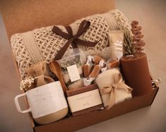 a box filled with lots of different items next to a pillow and coffee mugs