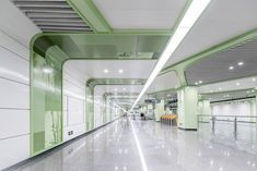 an empty green and white building with lots of lights on the ceiling, along with some benches