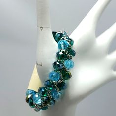 Mystique Silver With Blue Green Glass Beaded Stretch Bracelet Blue Beaded Stretch Bracelet For Party, Blue Round Beads Bracelets For Party, Elegant Blue Glass Bracelets, Adjustable Blue Party Bracelets, Elegant Blue Glass Bracelet, Blue Crystal Beaded Bracelets For Jewelry Making, Handmade Blue Crystal Bracelet For Party, Handmade Blue Crystal Party Bracelet, Elegant Blue Stretch Bracelet With Faceted Beads